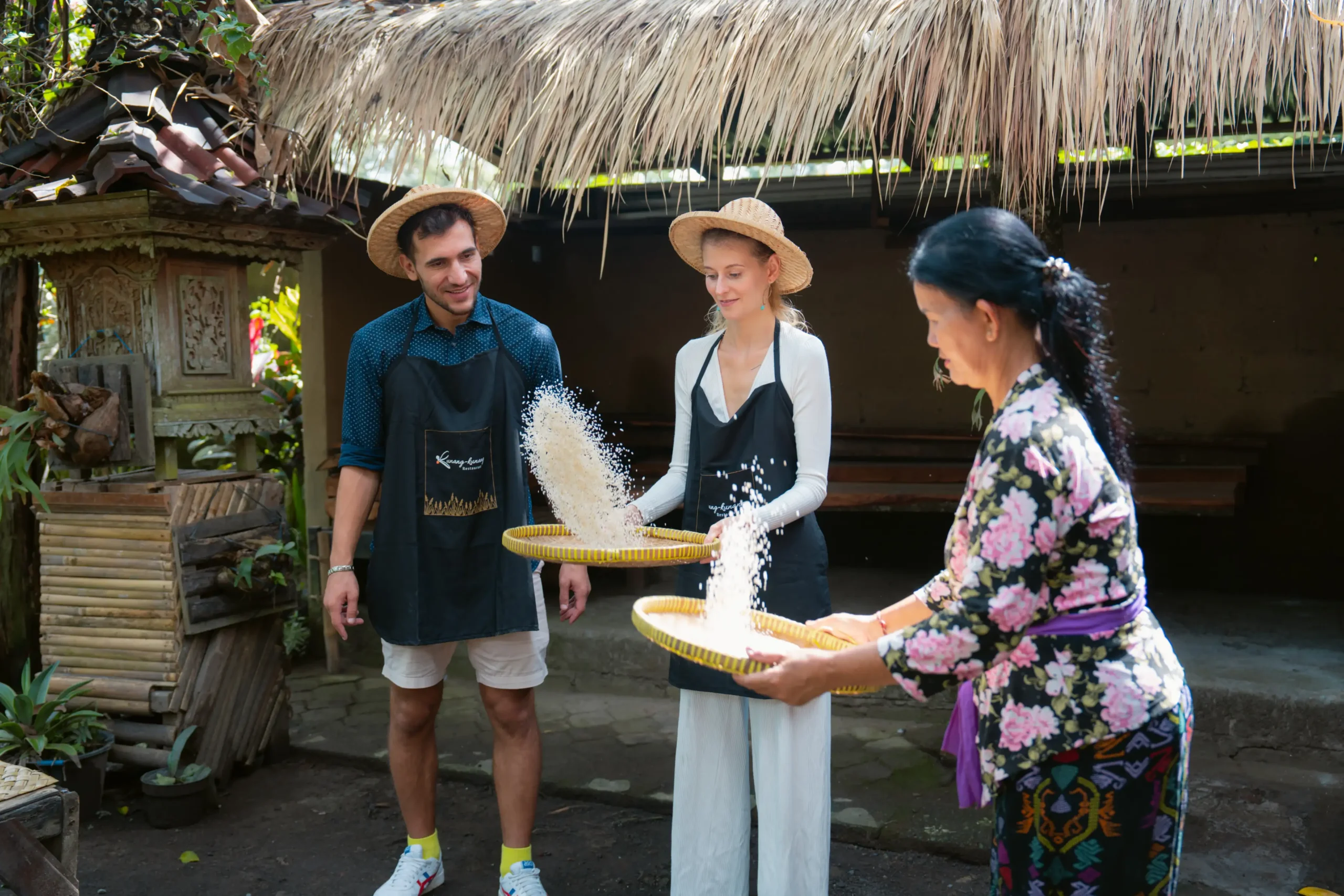 Guests winnowing rice by hand during a Balinese cooking class near Ubud